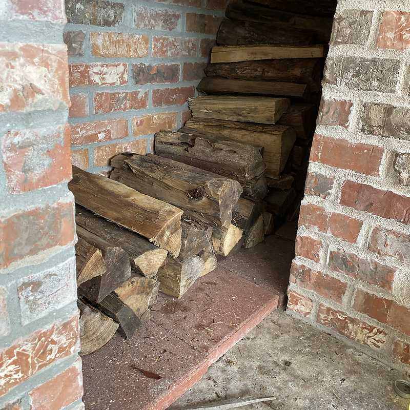 Wildman Firewood crew stacking delivered firewood for a customer