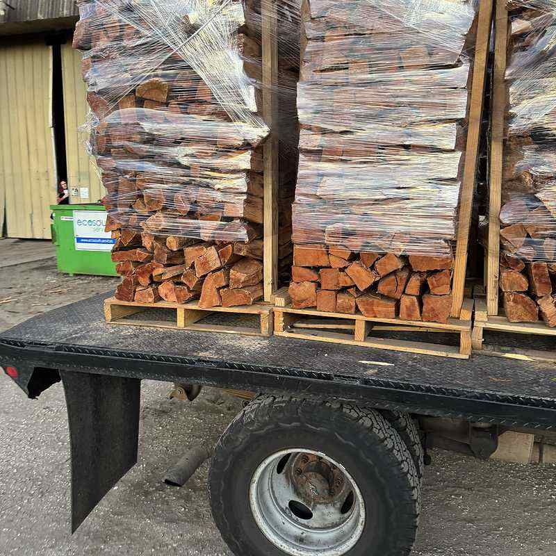 Wildman Firewood truck delivering firewood to a local customer