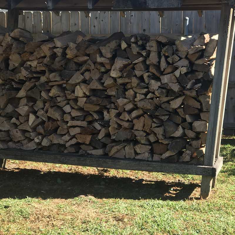 Wildman Firewood crew stacking and covering delivered firewood